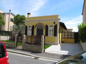 ein gelbes Haus mit einem Zaun davor in der Unterkunft Le Stagioni di Bacco in Monsummano