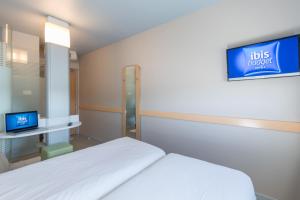 a hospital room with a bed and a tv at ibis budget Amberieu en Bugey/Chateau Gaillard A42 in Château-Gaillard