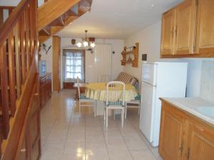 a kitchen and dining room with a table and a refrigerator at Fiocco di Neve in Montjovet