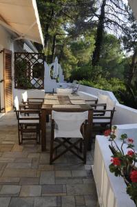 un patio con mesa de madera y sillas en Villa Pilion en Kolios