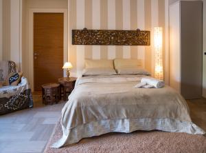 サンタ・テレーザ・ディ・リーヴァにあるAppartamenti Mantarro Travel and Livingのベッドルーム(大型ベッド1台、椅子付)