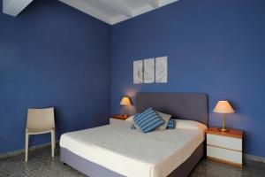 a bedroom with blue walls and a bed with two lamps at Residence Oliveto in Ceriale
