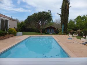 a swimming pool in a yard with a house at Le Chalet Bleu in Vergt-de-Biron