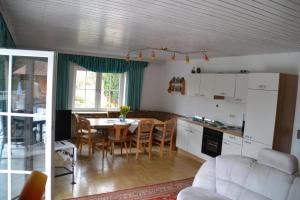 a kitchen and living room with a table and chairs at Erlebnispension Zum Wanderer Sepp in Arnbruck