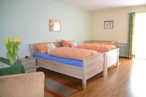 Schlafzimmer mit einem Bett mit orangefarbener und blauer Bettwäsche in der Unterkunft Erlebnispension Zum Wanderer Sepp in Arnbruck