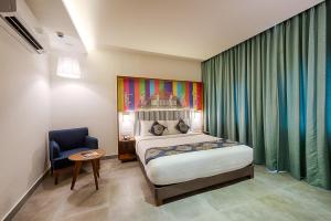 um quarto com uma cama e uma cadeira num quarto em The Belstead em Chennai