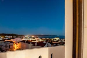 Blick auf die Stadt in der Nacht von einem Gebäude in der Unterkunft Nazaré Hostel - Rooms & Dorms in Nazaré