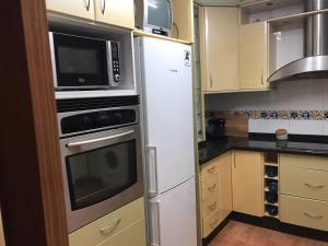 y cocina con nevera y microondas. en Apartamento Turistico Loyola, en Benidorm