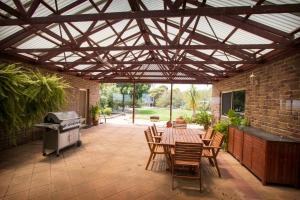 a patio with a table and chairs and a grill at Limestone Ridge in Tailem Bend