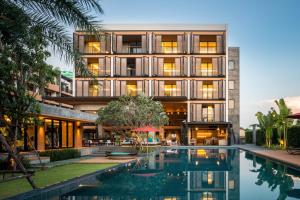 una vista exterior de un edificio con piscina en The Silver Palm Wellness Resort, en Bangkok