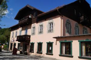 a large pink building with a black roof at Hotel YOUHEY am Wolfgangsee in Strobl