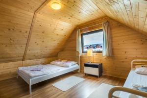 a room with two beds in a wooden cabin at Słoneczny Ogród in Władysławowo