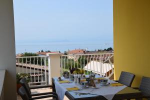 una mesa en un balcón con vistas al océano en Villa Mimosa, en Bardolino