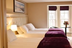 a hotel room with two beds and a window at Rooms At Rue in Omagh