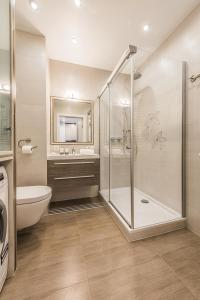 een badkamer met een douche, een toilet en een wastafel bij P&O Apartments Metro Mlociny in Warschau