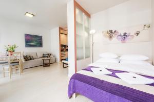 a bedroom with a bed and a living room at P&O Apartments Metro Mlociny in Warsaw