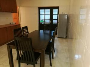 cocina con mesa, sillas y nevera en Vistana Residence, Bayan Lepas Penang en Bayan Lepas
