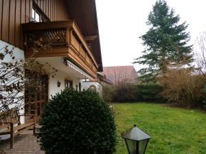 ein Haus mit einem Balkon und einem Baum im Hof in der Unterkunft Ferienhaus Lerche in Bad Birnbach