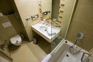 a bathroom with a sink and a shower and a toilet at Fantasia Deluxe Hotel in Kuşadası