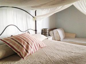 LubrianoにあるHoneymoon Cottageのベッドルーム1室(天蓋付きベッド1台、ソファ付)