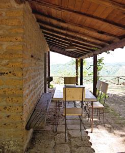LubrianoにあるHoneymoon Cottageの煉瓦の壁の下に座るテーブルと椅子
