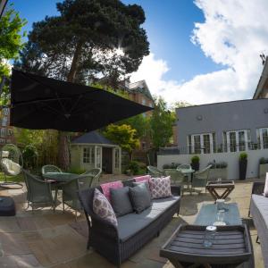a patio with a couch and an umbrella at The Orchid Hotel in Bournemouth