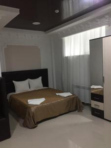 sypialnia z łóżkiem i dużym oknem w obiekcie Alkor Hotel w Wołgogradzie