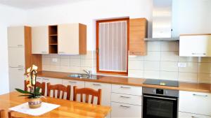 eine Küche mit einem Holztisch, einem Waschbecken und einer Theke in der Unterkunft Holiday House Kanalec in Drežnica