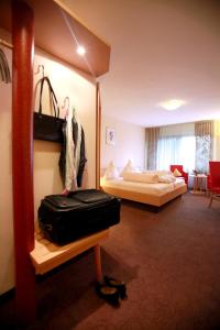 una habitación de hotel con una cama y una maleta en Hotel Am Hirschhorn - Wellness - Spa - and more, en Wilgartswiesen