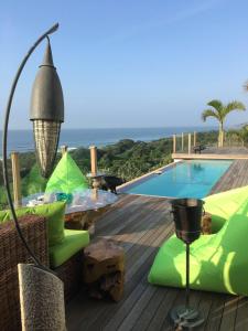 a deck with a pool and a table and chairs at Nakai Beach Homestay in Trafalgar