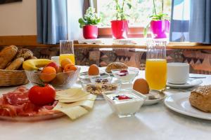 a table with a breakfast of eggs and bread and orange juice at Garni Meinrad in Auer