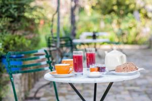 una mesa blanca con bebidas y comida. en Villa Kefalomandouko, en Corfú