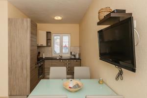 een keuken met een tafel en een televisie aan de muur bij Villa Joma 2 in Trogir