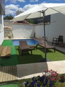 a patio with two chairs and an umbrella at Casa Oretani in Picón