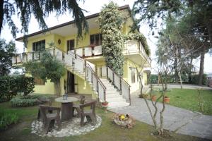 una casa gialla con tavolo e sedie nel cortile di Agostini Daniela B&B a Cadoneghe