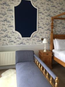 a bedroom with a bed and a chair and a lamp at Albany Lodge in Portrush