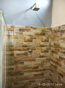 a bathroom with a shower with wooden tiles at Chika House in Gili Trawangan