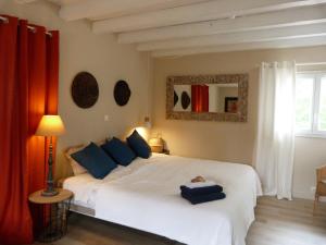 a bedroom with a large white bed with blue pillows at Maison Hamak in Urrugne