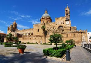 un grand bâtiment avec une tour d'horloge au sommet dans l'établissement B&B Addauru, à Palerme