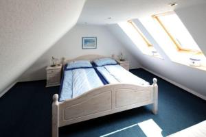 una camera da letto con un letto in mansarda con due finestre di Ferienwohnungen im daenischen Landhausstil a Altkamp