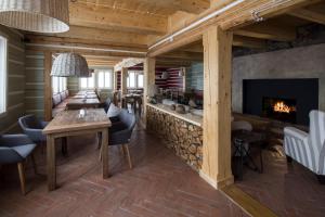 - un salon avec une cheminée, une table et des chaises dans l'établissement Hotel Bouda Helena, à Pec pod Sněžkou