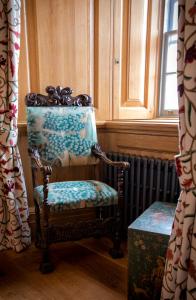 a chair sitting in a room next to a window at Mingary Castle - Restaurant with Rooms in Kilchoan