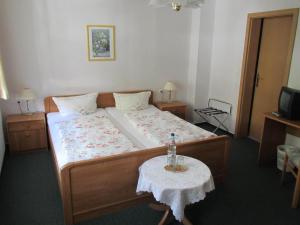 a small bedroom with a bed and a table at Hotel Pension Am Kurzentrum in Bad Suderode