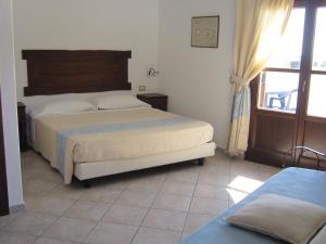 a bedroom with a bed and a window at Hotel Resort Nuraghe Arvu in Cala Gonone