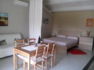 ein Schlafzimmer mit einem Bett und einem Tisch und Stühlen in der Unterkunft Le Case Di Bacco in Santa Venerina
