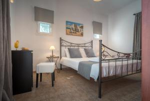 a bedroom with a bed and a table and a chair at Aelia Villa in Kallithea