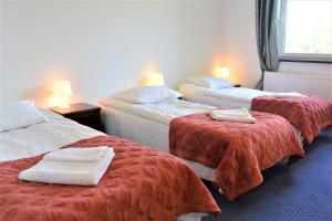 a hotel room with two beds with towels on them at Hotel Eden in Rzgów