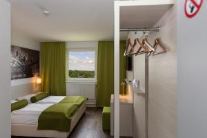 una camera d'albergo con letto e finestra di LifeHotel Vienna Airport a Fischamend-Dorf