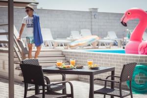 a man standing next to a table with food and a pool at SeaZone in Zatoka