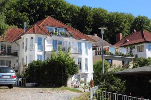 a white house with a car parked in front of it at Ferienwohnung Anemone in Sassnitz